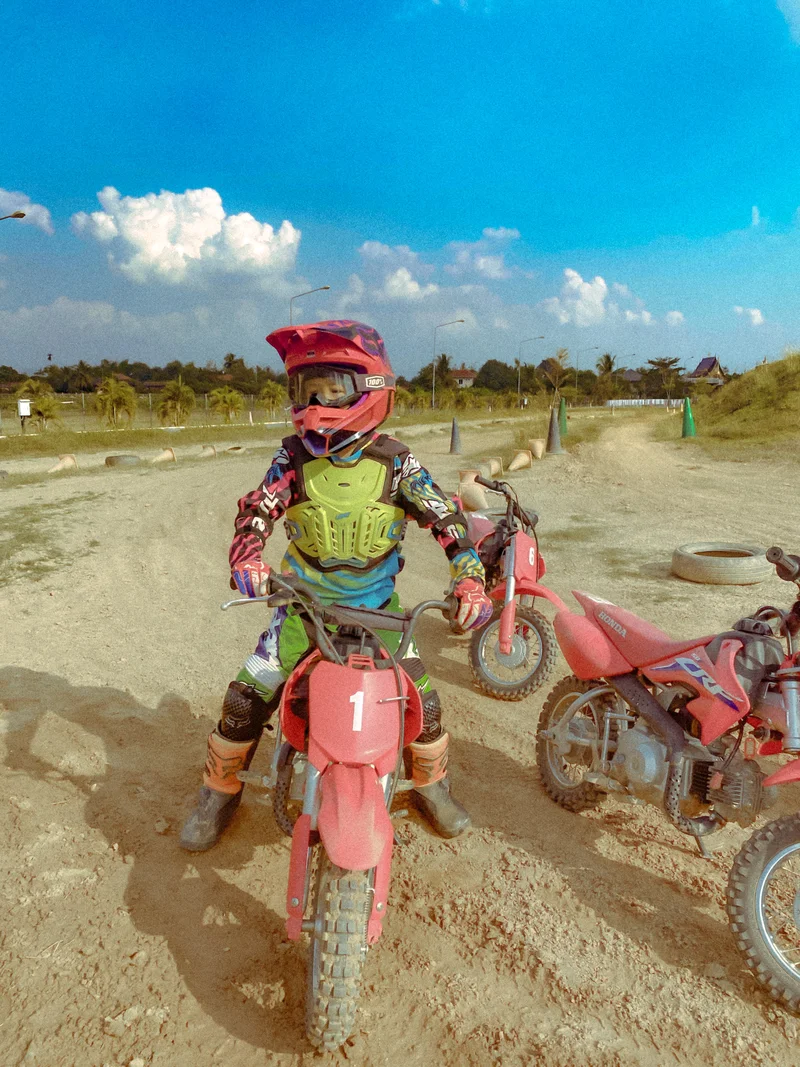 Our son wearing a helmet and protective clothing while learning to ride a small off-road motorbike