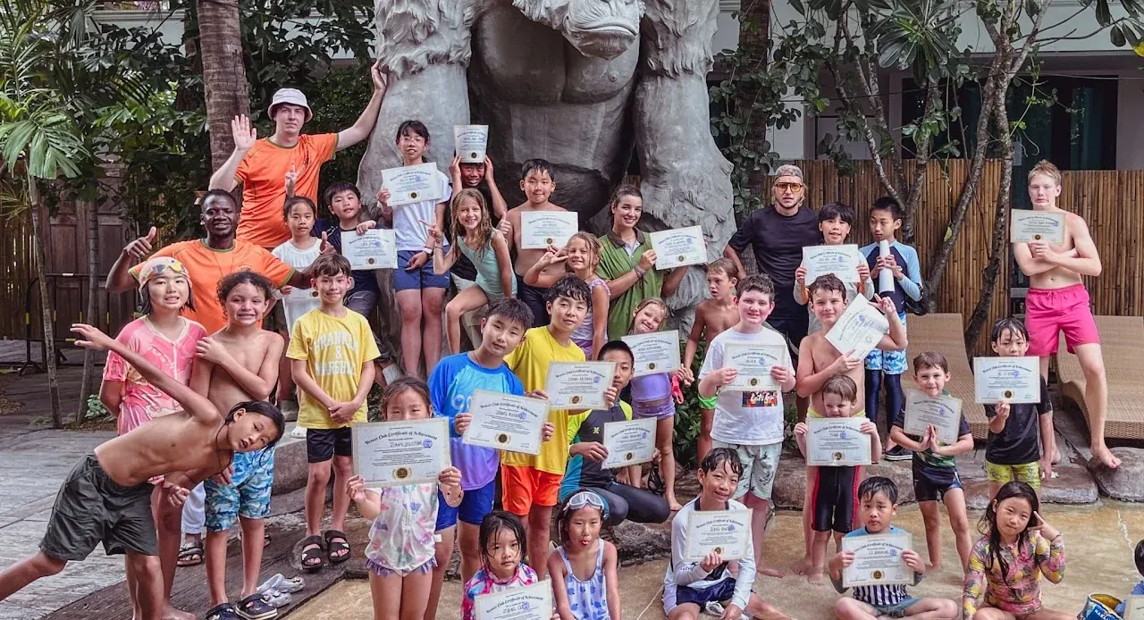 Beaver Club campers and adults holding their artwork in a large group photo