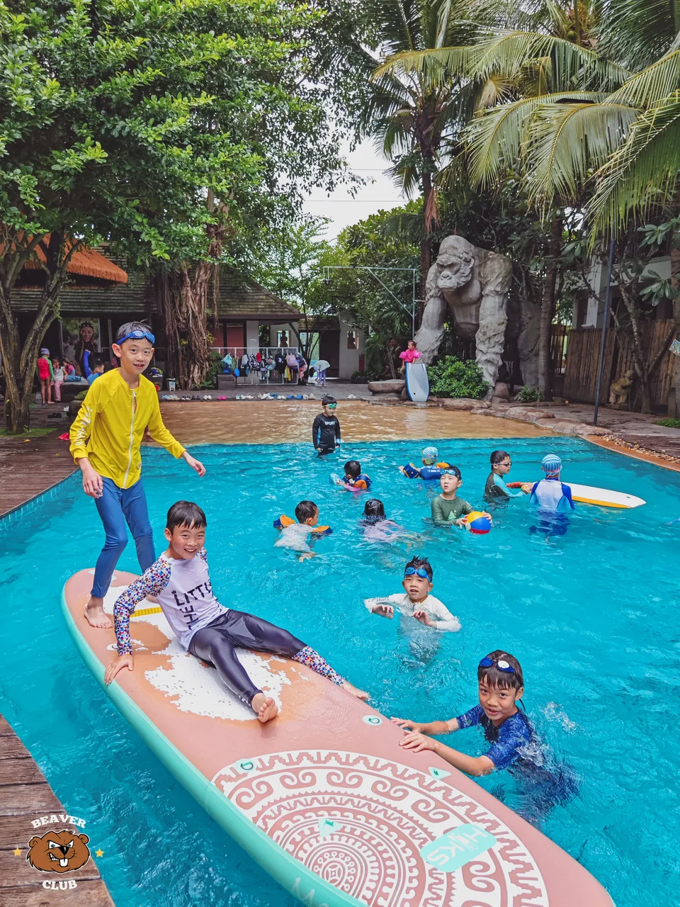 Children playing together with a paddleboard in the Beaver Club swimming pool