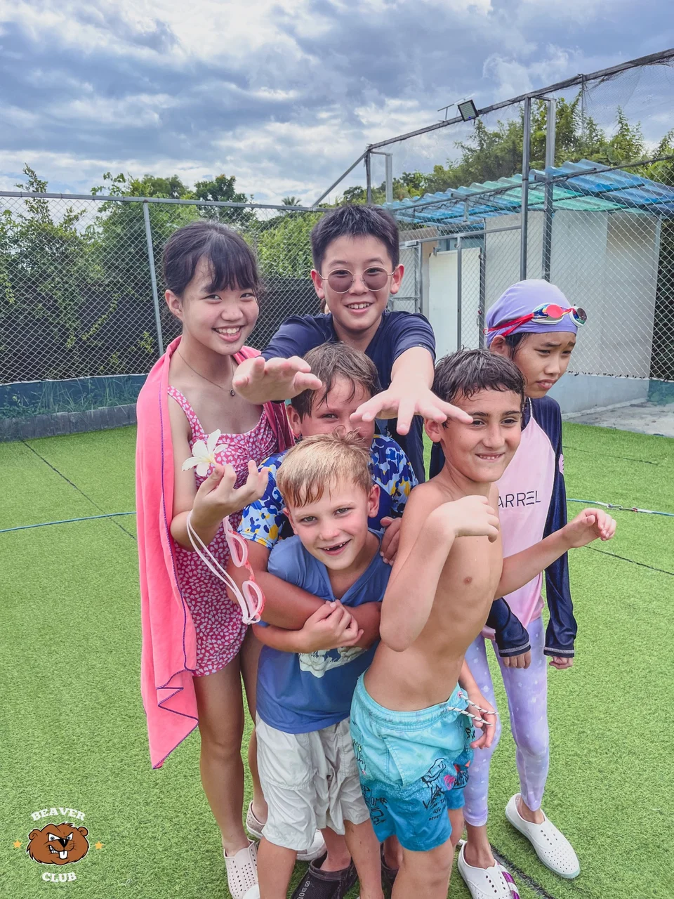 Camp friends smiling together on the Beaver Club sports field after swimming