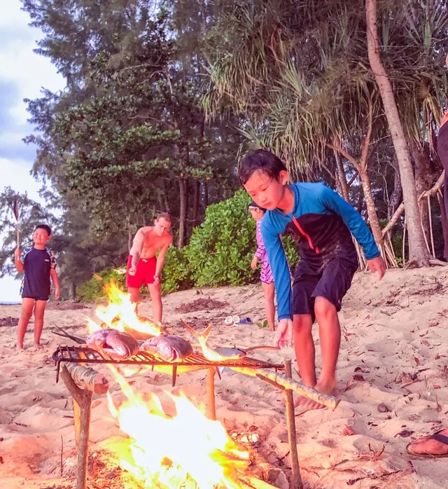 Children cooking over a campfire on the island beach