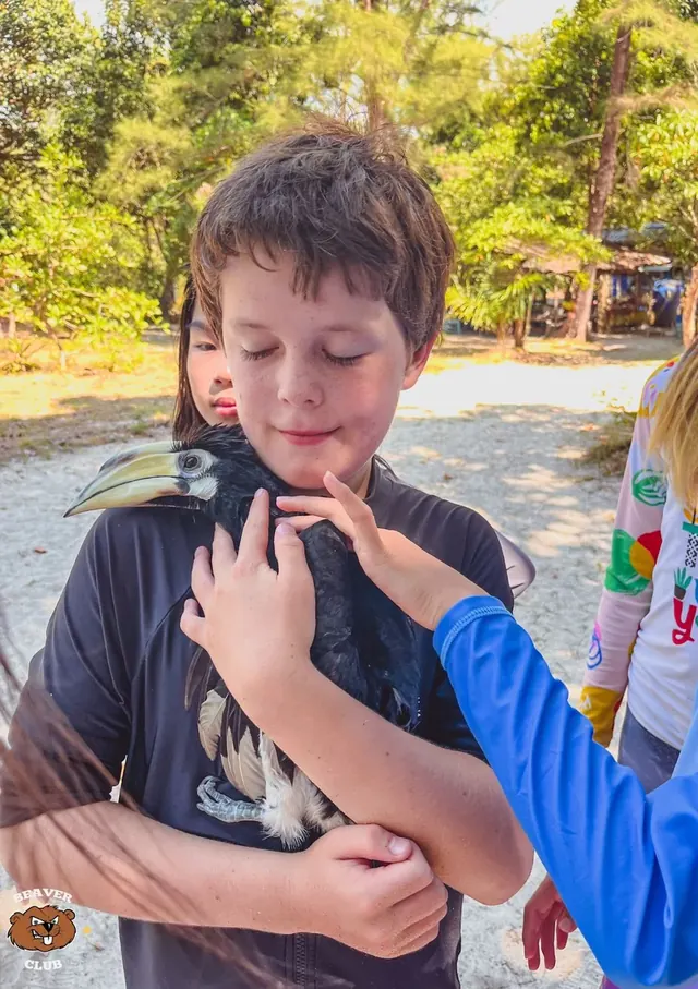 A child holding a bird on a Beaver Club island trip