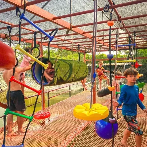 Children climbing through the covered obstacle playground