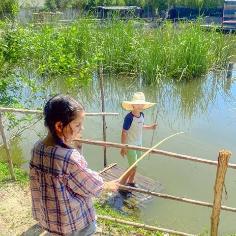 Children fishing beside the green pond at Beaver Club