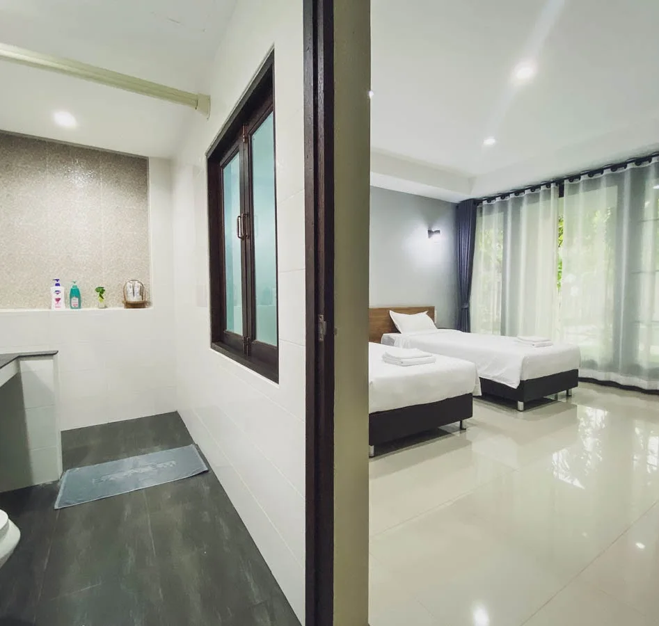 A private bathroom beside a bright family homestay bedroom