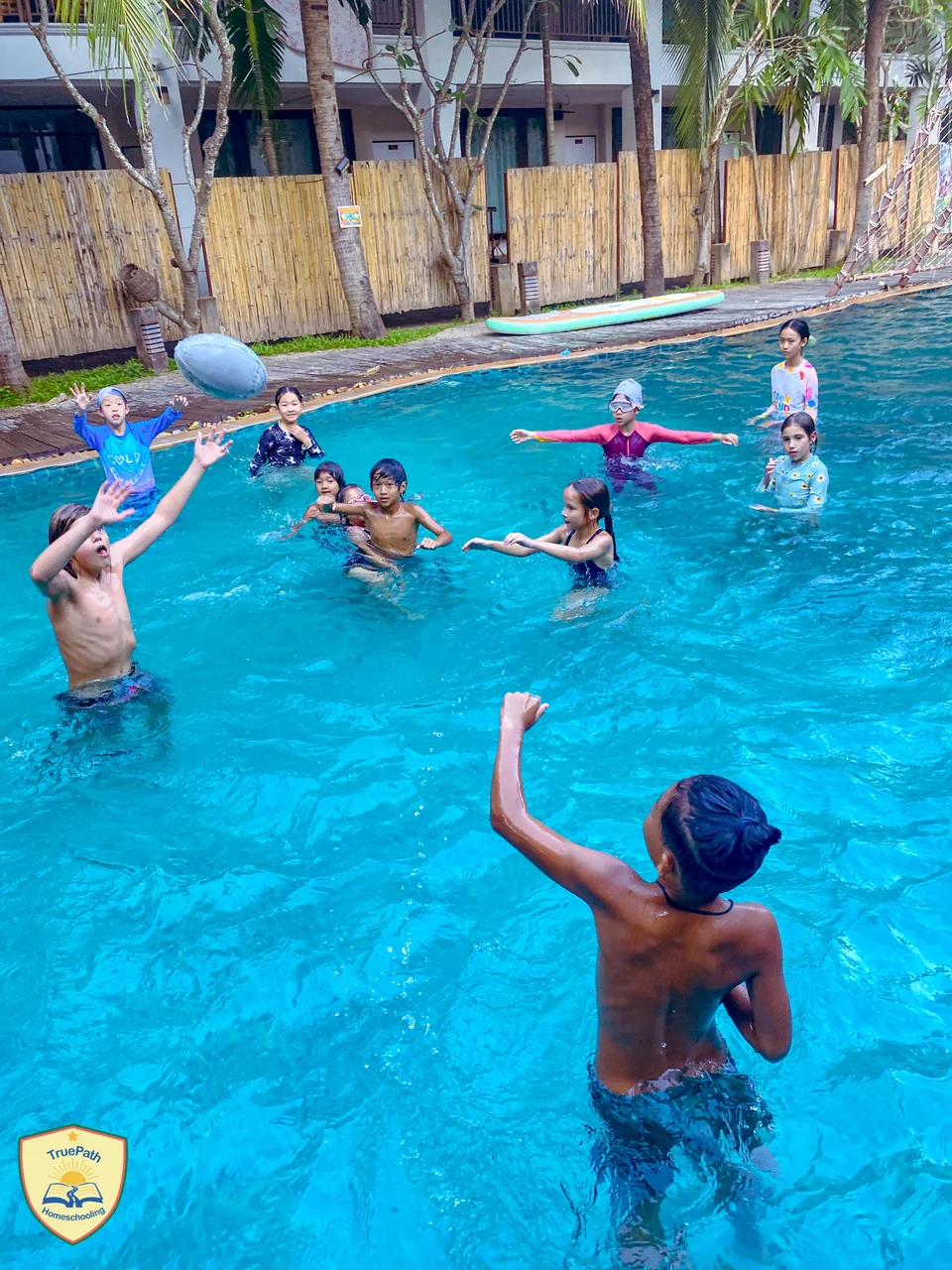 Children playing a ball game together in the Beaver Club swimming pool