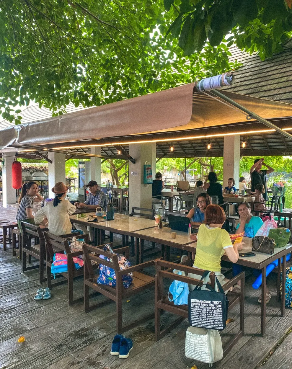 Adults and children spending time at outdoor tables at Beaver Club